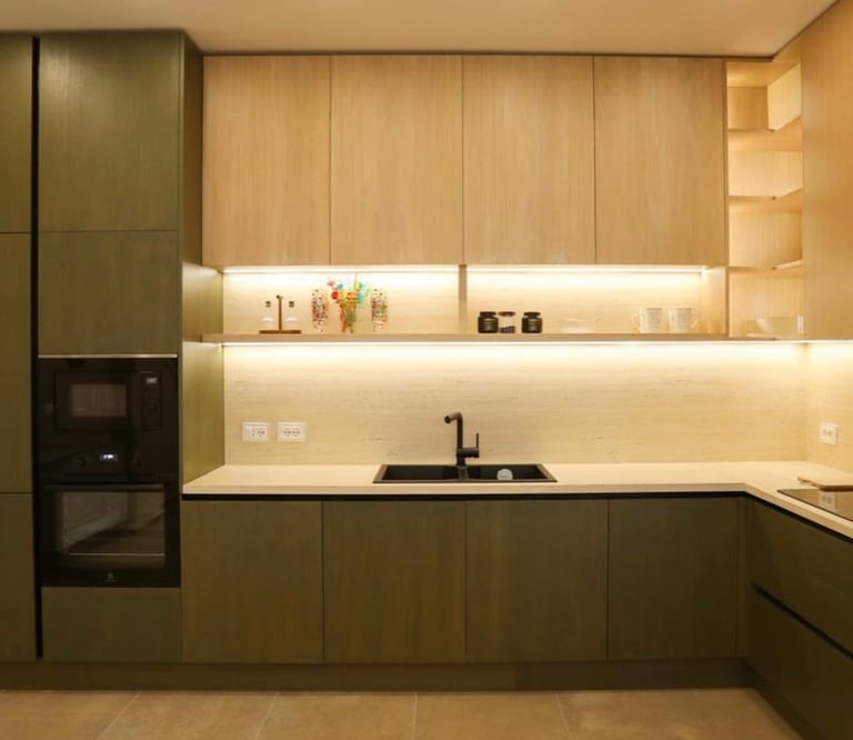 Modern kitchen with two-tone cabinetry in olive green and natural wood, featuring under-cabinet lighting, minimalist design, and integrated appliances.